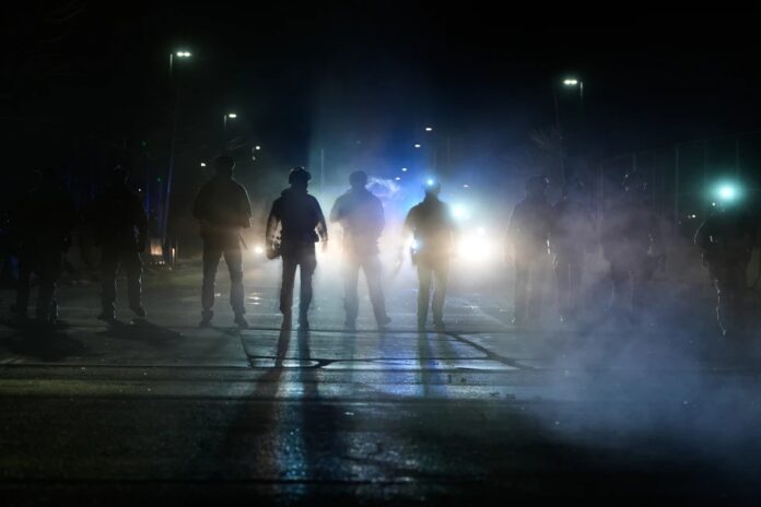 Agentes federales de inmigración, en el exterior del edificio federal Bishop Whipple tras emplear gases lacrimógenos, el 12 de enero de 2026, en Minneapolis. (AP Foto/Jen Golbeck)
